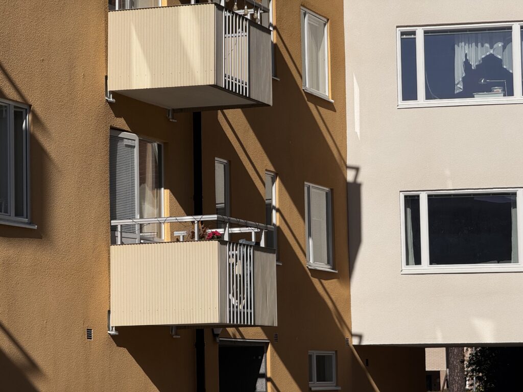 Gula och vita putsfasader med balkonger